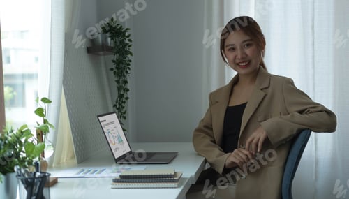Preview: Portrait of confident young entrepreneur sitting at modern workplace and smiling to camera.