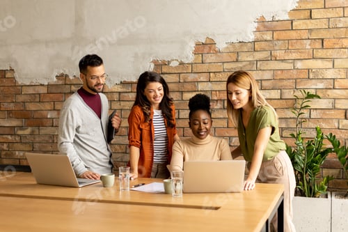 Preview: Young multiethnic startup team working by the brick wall in the industrial style office