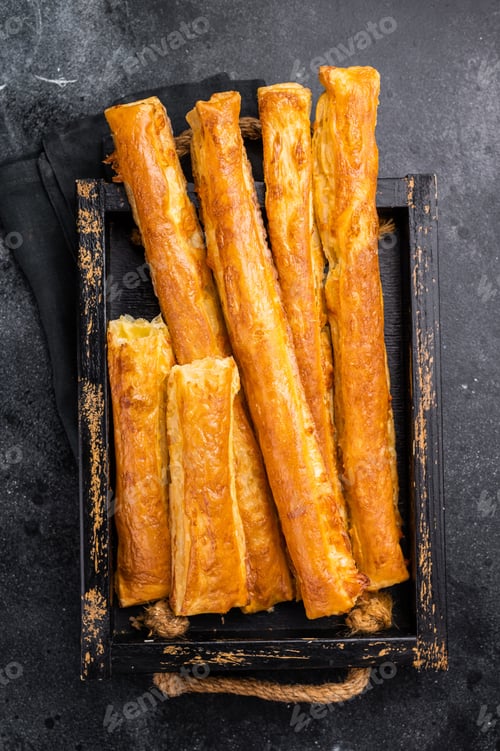 Preview: Bread sticks with cheese and salt. black background. top view