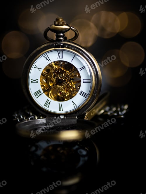 Preview: Vertical shot of an antique gold pocket watch isolated on a blurred background
