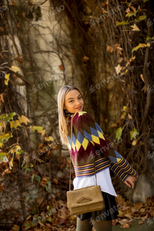 Preview: Happy young woman standing in autumn park