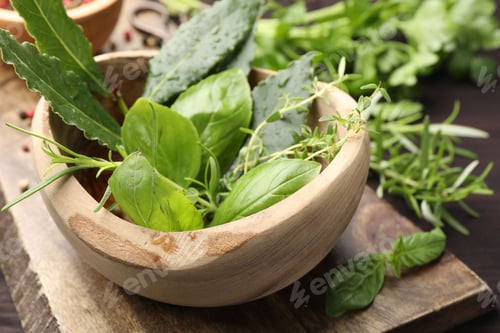 Preview: Mortar with different fresh herbs on wooden table, closeup
