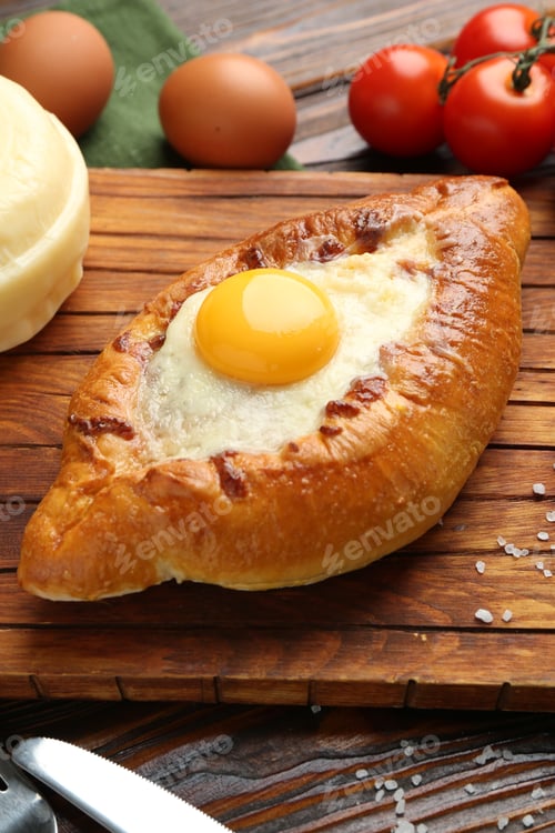 Preview: Tasty khachapuri with cheese and other products on wooden table, closeup