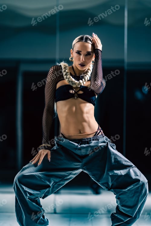 Preview: Vertical view of an attractive girl posing before the mirror in a dance studio