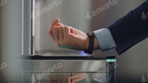 Preview: Hand smartwatch touching sensor control panel unlocking office turnstile closeup