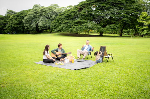 Preview: Happy multi generational Asian family enjoying picnic in the park
