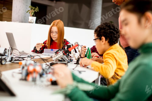 Preview: Happy kids programming electric toys and robots at robotics classroom