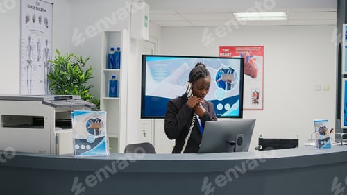 Preview: African american receptionist working at hospital reception counter