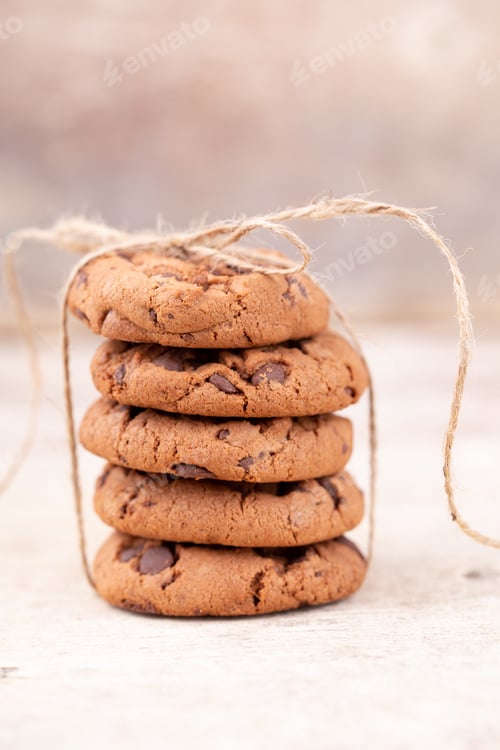 Preview: Image shows a stack of american chocolate chip cookies on rustic wooden plank.