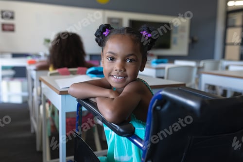 Preview: Portrait of smiling african american elementary girl sitting on wheelchair in classroom