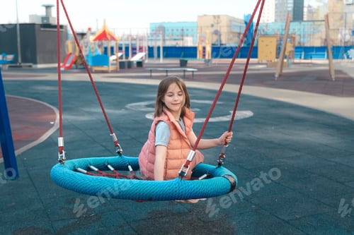 Preview: cute girl walks and swings on a swing outdoors