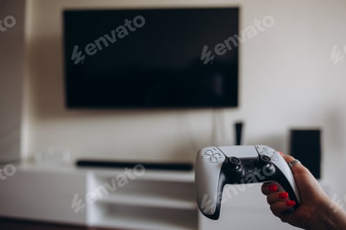 Preview: A young woman is playing a game console. Girl gamer and computer video games.