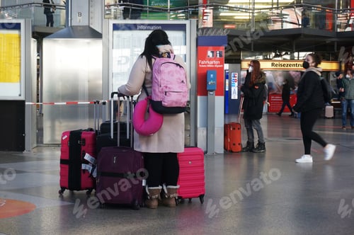 Preview: Woman traveling, waiting at Düsseldorf Central station, carrying a lot of pink luggage.
