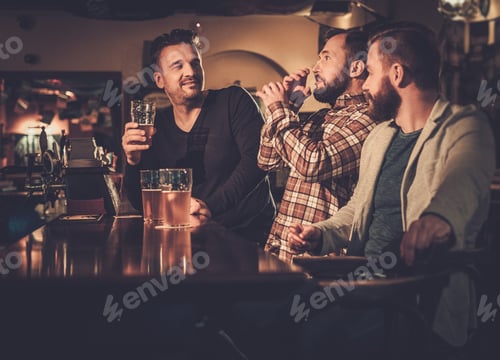 Preview: Cheerful old friends having fun and drinking draft beer at bar counter in pub.