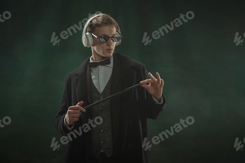 Preview: Young man in art action isolated on dark green background. Retro style, comparison of eras concept