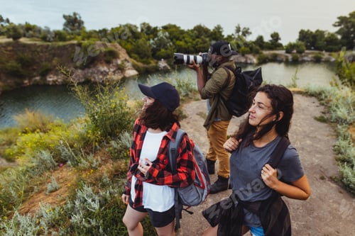 Preview: Group of friends, young men and women walking, strolling together outskirts of city, in summer