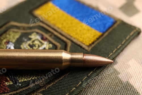 Preview: Bullet and military Ukrainian patch on pixel camouflage, closeup