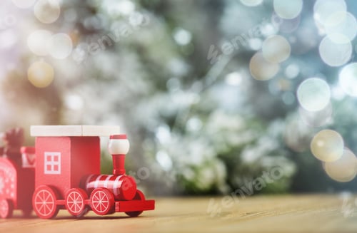 Preview: Toy Christmas wooden train on background of snow, bokeh and Christmas tree. New Year and Christmas c