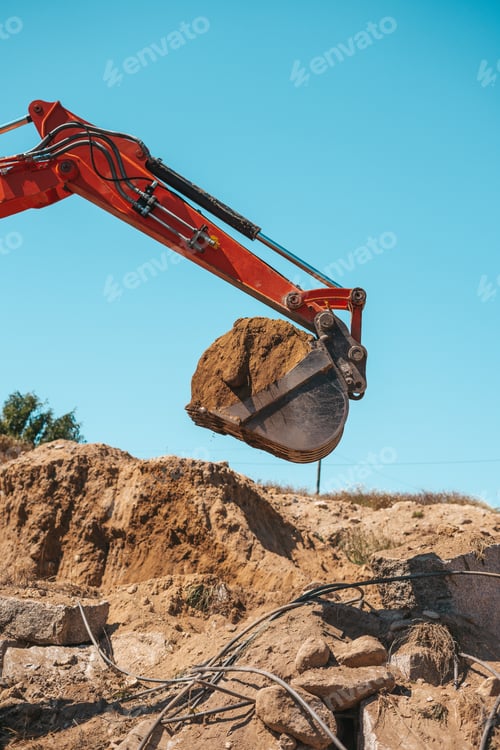 Preview: Closeup of a backhoe with dirt against sky