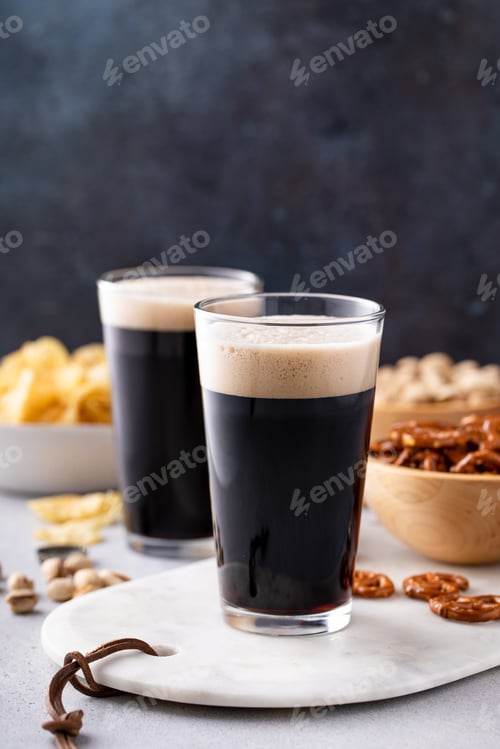 Preview: Dark stout beer in tall glasses on the table