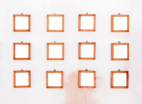 Preview: Twelve small simple square wooden frames displayed on a wall