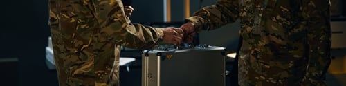 Preview: Handshake Between Military Personnel Holding Silver Briefcase