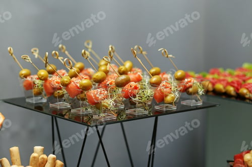 Preview: Eating at the event. Disposable plastic cups with snacks - salmon with olive and microgreens.