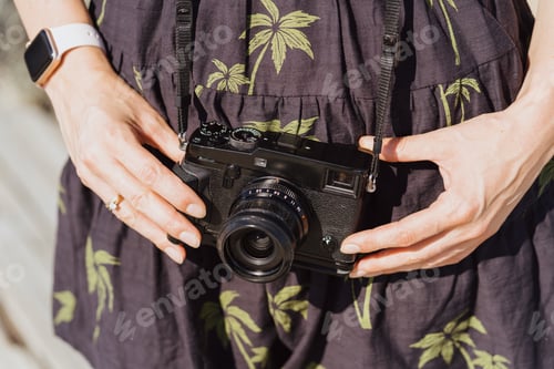 Preview: Woman hands holding a small camera in her hands