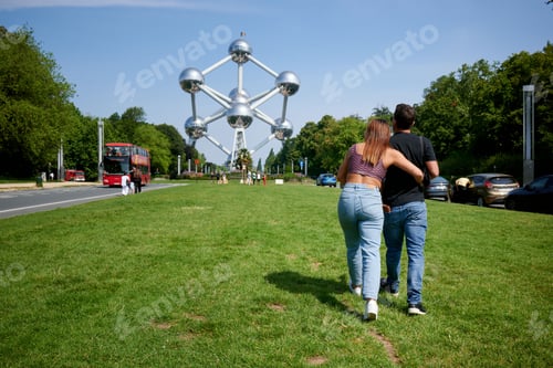 Preview: Back view of Hispanic couple walking towards the Atomium in Brussels