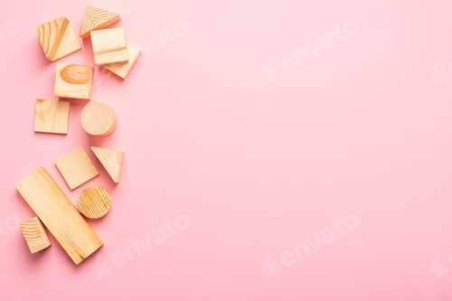 Preview: Children's wooden toys pink background. Frame from developing cubes. Copy space. Top view