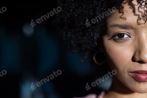 Preview: Close-up of woman with curly hair and hoop earring, looking confidently, copy space