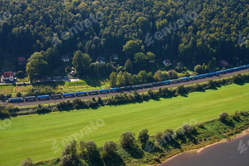 Preview: Landscape with forest, green fields and freight train on railway