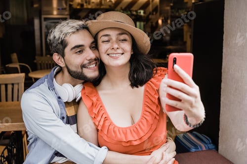Preview: Happy couple having fun doing selfie outdoor in bar restaurant - Tourist, summer travel concept