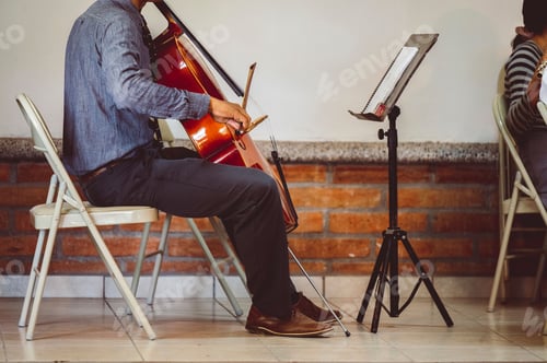Preview: Closeup of a man sitting and playing a cello