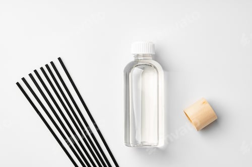 Preview: A minimalist display of essential oil and black diffuser sticks on a clean white background