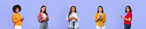 Preview: Happy millennial diverse women bloggers in casual use smartphones