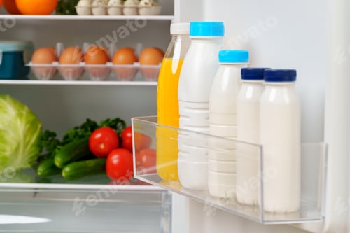 Preview: White Refrigerator Open With Fresh Produce and Dairy