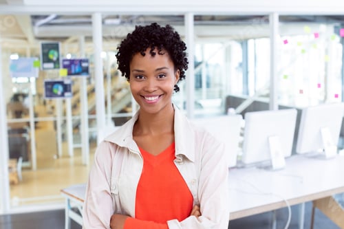 Preview: Confident African American woman smiling in modern office with computers