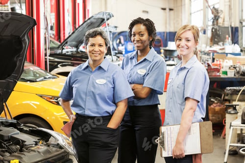 Preview: Portrait of three smiling female mechanics in auto repair shop