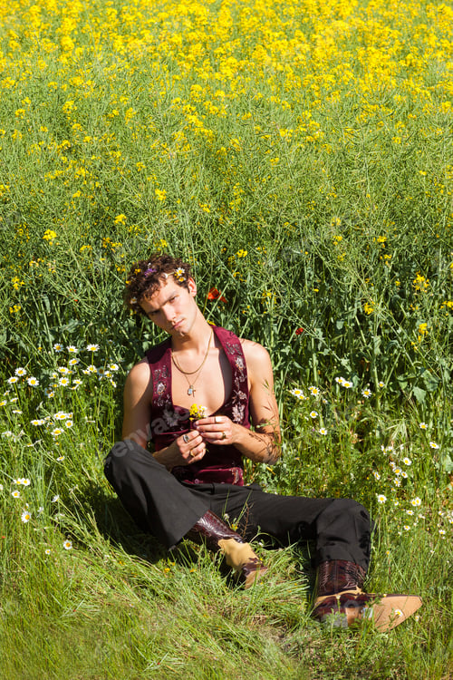 Preview: Young gay man lying on field with flowers