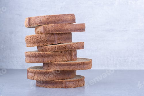 Preview: Brown bread slices stacked up on marble background