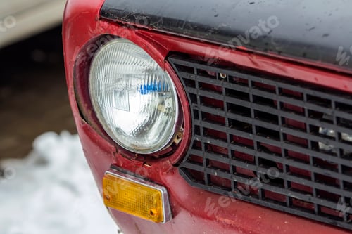 Preview: Red vintage car on a festival of old cars. Retro car's headlight close up.