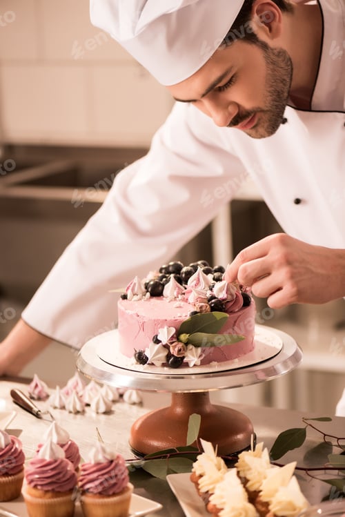 Preview: portrait of confectioner decorating cake in restaurant kitchen