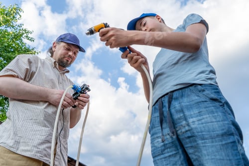 Preview: Dad and teenage son work together on the street near the garage. Outdoor activity. Family spend time
