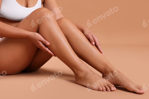 Preview: Epilation. Woman showing her legs with smooth soft skin on beige background, closeup