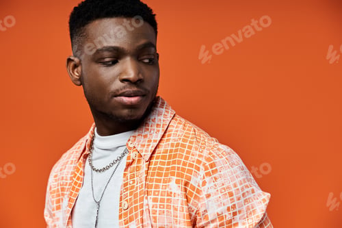 Preview: Stylish Afro-American Man Poses in Vibrant Orange Attire