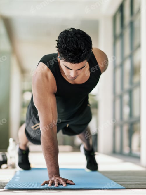 Preview: Shot of a young man doing pushups during his workout at home