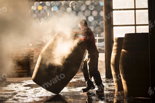 Preview: Male cooper working in cooperage with whisky casks