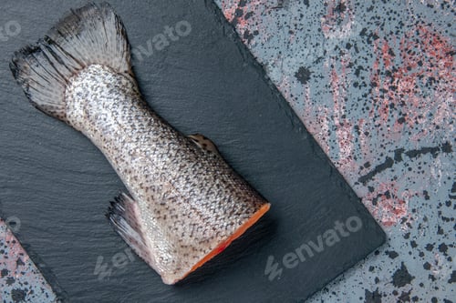 Preview: Close up view of fresh raw fish on dark color tray on blue black mix colors background with free