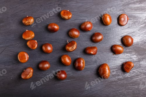 Preview: pile of sweet chestnuts on black wooden background